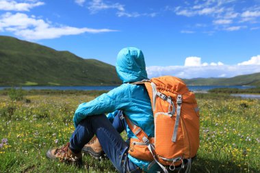 Dağlarda yürüyüş yapan genç bir kadın.