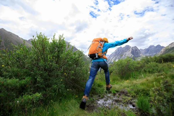 Dağlarda yürüyüş yapan genç bir kadın.