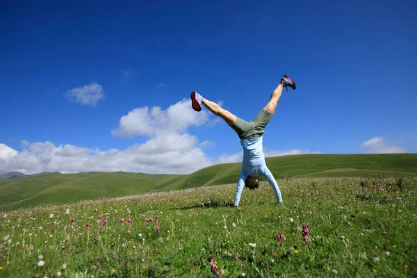 Frau macht Handstand Stockfoto