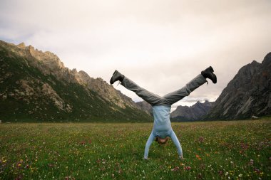 Genç kadın amuda kalkıyor.