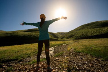 Kollarını açmış genç bir kadın. 