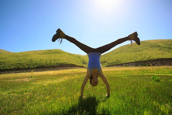 Jonge fitness vrouw doet handstand — Stockfoto