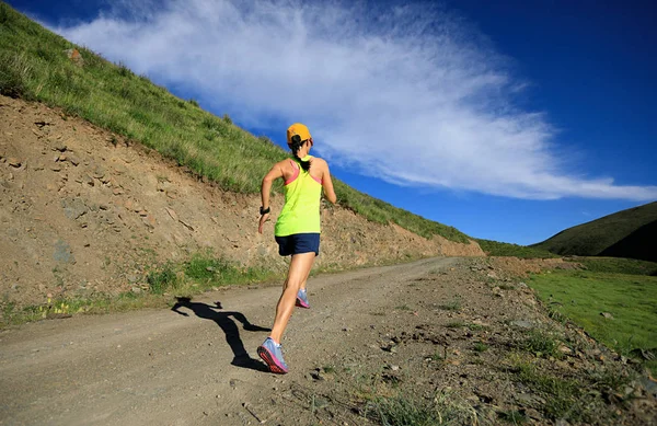 Mujer corriendo por sendero de montaña — Foto de Stock