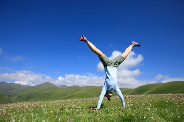 Genç kadın amuda kalkıyor.