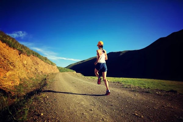Mujer corriendo en carretera de montaña —  Fotos de Stock