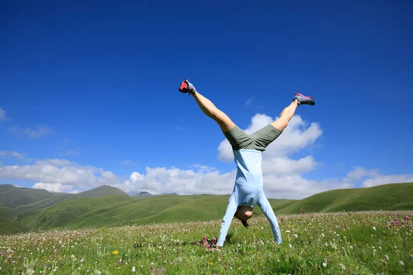 Mujer joven haciendo handstand — Foto de Stock