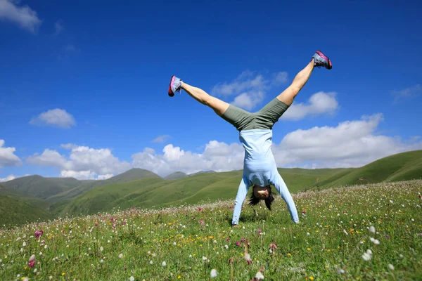 Mujer joven haciendo handstand — Foto de Stock