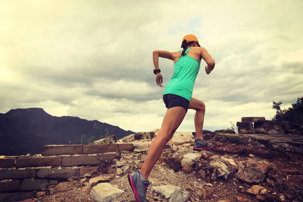 Jeune femme courant au sommet de la montagne — Photo