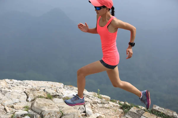 Νεαρή γυναίκα τρέχει στην κορυφή του βουνού — Φωτογραφία Αρχείου