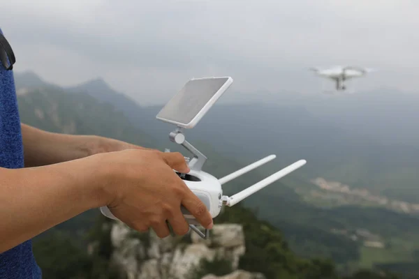 hands holding remote control of drone