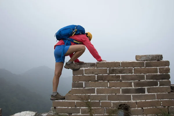 Femme escalade sur mur de briques — Photo
