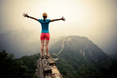 Kollarını açmış genç bir kadın.