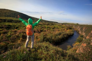 Sırt çantası ile genç kadın uzun yürüyüşe çıkan kimse