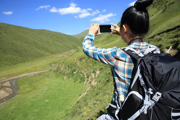 Young woman hiker taking picture — Stock Photo, Image