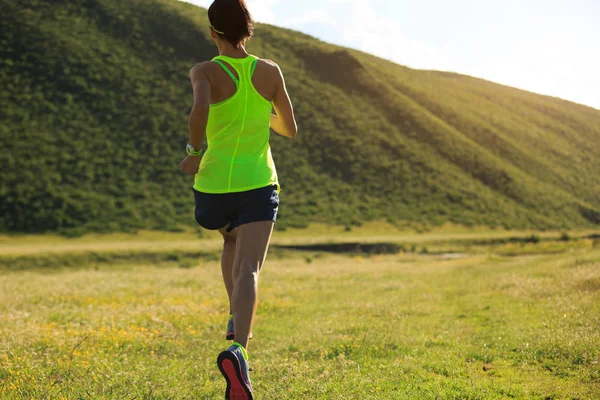 ผู้หญิงวิ่งบนทุ่งหญ้าภูเขา — ภาพถ่ายสต็อก