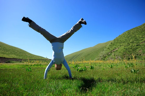 Jonge fitness vrouw doet handstand Stockafbeelding