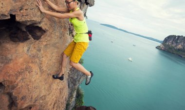 Genç kadın deniz cliff tırmanma