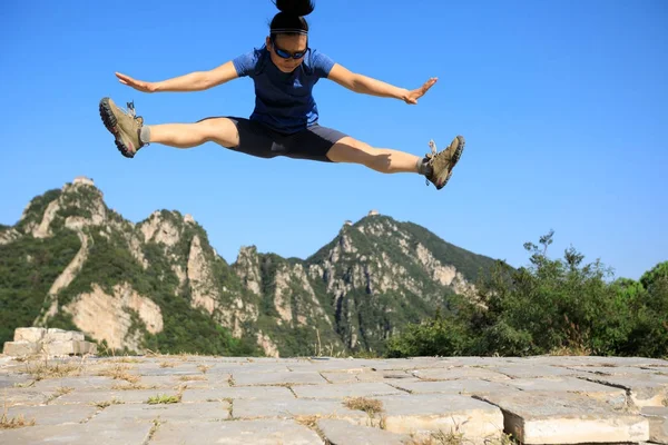 Jovem mulher pulando na montanha — Fotografia de Stock