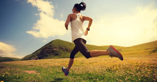 Young woman running on grassland — Stock Photo, Image