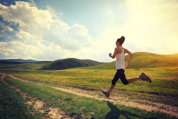 Mujer joven corriendo en pastizales —  Fotos de Stock