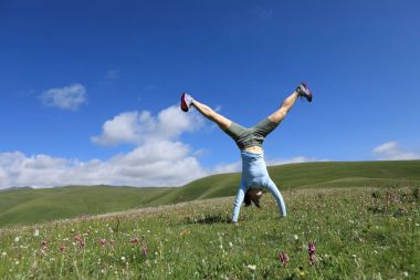 Genç kadın amuda kalkıyor.
