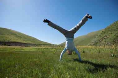 Genç kadın amuda kalkıyor.