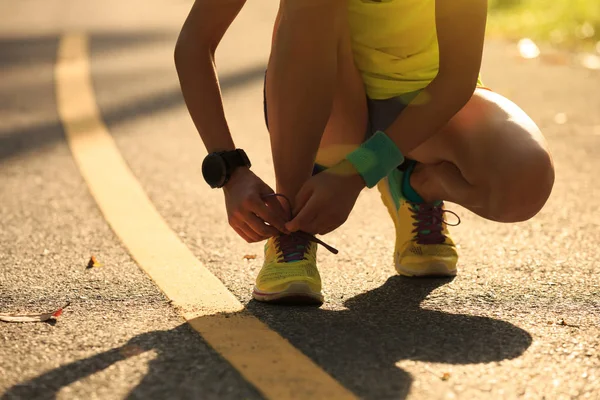 Giovane donna corridore legatura shoelace — Foto Stock