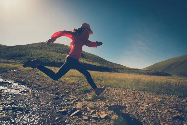 Mujer joven corriendo en pastizales —  Fotos de Stock