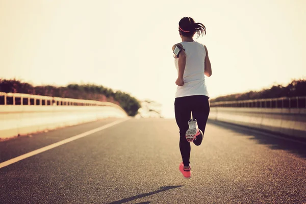 Jeune femme courant sur la route — Photo