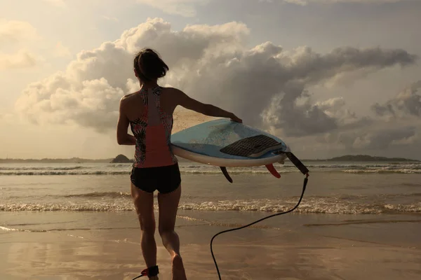 Giovane surfista con tavola da surf a piedi fino al mare — Foto Stock