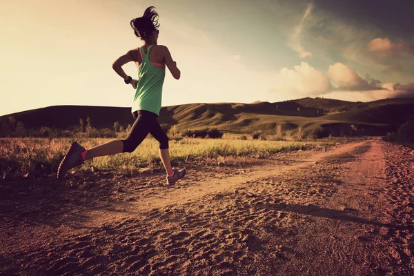 Mujer joven corriendo por el camino de tierra — Foto de Stock