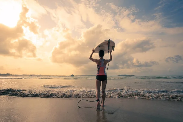 Giovane surfista con tavola da surf a piedi fino al mare — Foto Stock