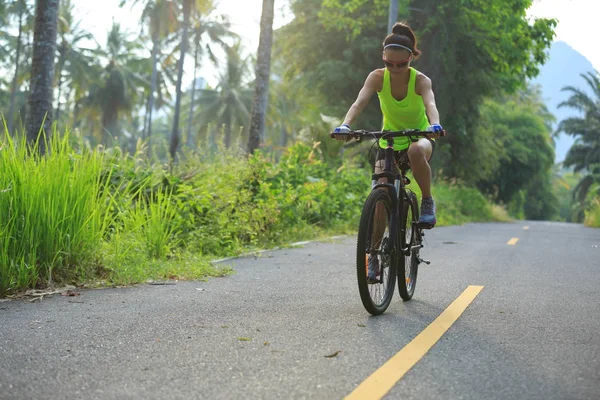 Молода жінка їде на велосипеді по стежці — стокове фото