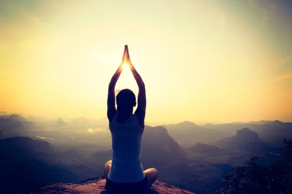 Young woman meditating on mountain peak — Stock Photo, Image