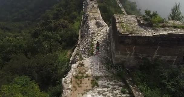 Frau läuft auf große Mauer — Stockvideo