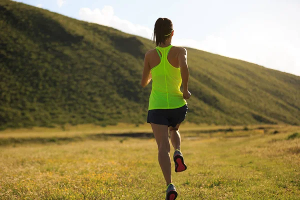 Woman running on grassland trail — Stock Photo, Image