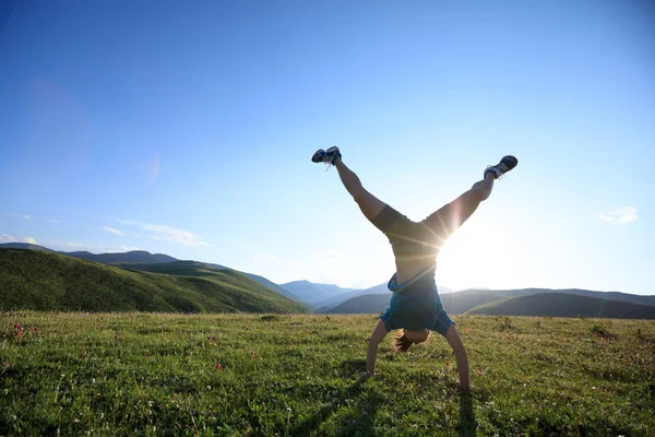 Mujer joven haciendo handstand — Foto de Stock