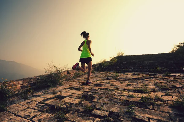 Jonge vrouw lopen bij grote muur — Stockfoto