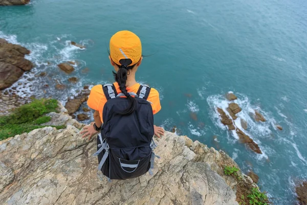 Mujer disfrutando de la vista en acantilado junto al mar —  Fotos de Stock