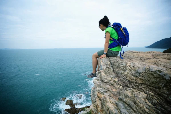 Mujer disfrutando de la vista en acantilado junto al mar — Foto de Stock