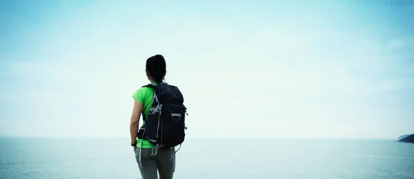 Mulher desfrutando de vista sobre penhasco à beira-mar — Fotografia de Stock