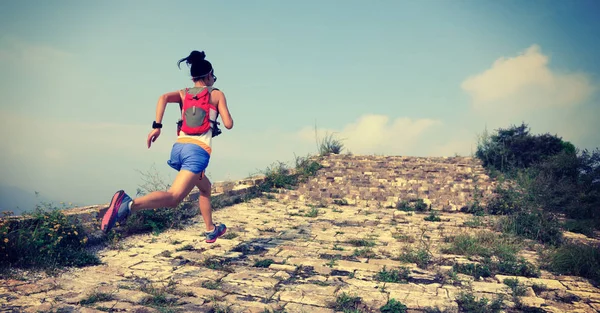 Jeune femme courant au grand mur — Photo