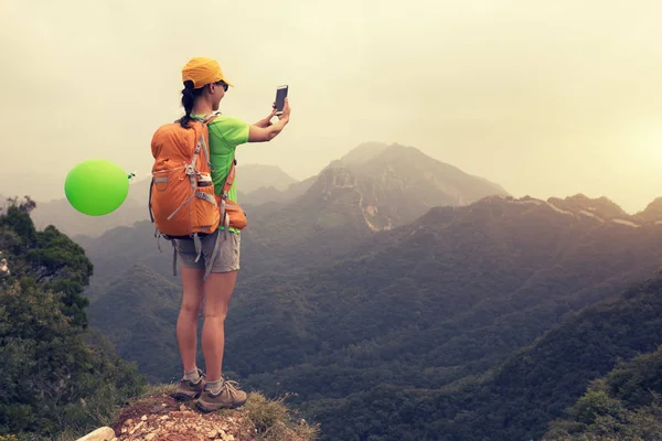 Genç Kadın Backpacker Dağın Tepesinde Smartphone Kullanarak — Stok fotoğraf