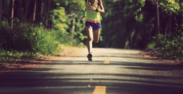 熱帯林のトレイルを走る若いフィットネス女性 — ストック写真