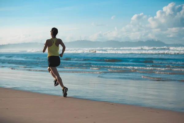 Giovane donna che corre sulla spiaggia — Foto Stock