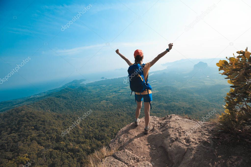 young woman on edge of mountain