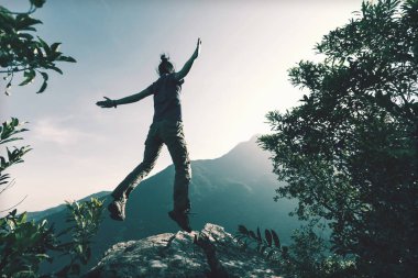 başarılı genç kadın dağ cliff üzerinde atlama