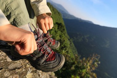 dağın tepesinde bağcık bağlama başarılı genç kadın uzun yürüyüşe çıkan kimse 