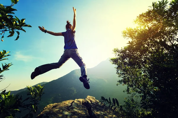 Junge Frau springt auf Klippe — Stockfoto