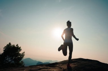 Gündoğumu dağın tepesinde çalışan genç kadın  